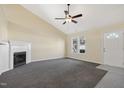Spacious living room with a vaulted ceiling, fireplace, ceiling fan, and an entrance door at 1432 E Stonemason Dr, Fuquay Varina, NC 27526