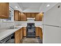 Functional kitchen with white countertops, oak cabinets, black appliances, and laminate flooring at 1442 Barton Place Dr, Raleigh, NC 27608