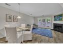 A dining and living room with a fireplace and access to the outdoors is lit by natural light at 1442 Barton Place Dr, Raleigh, NC 27608