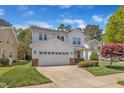 Charming two-story home with a well-manicured front lawn and a two-car garage on a sunny day at 145 Ryder Cup Cir, Raleigh, NC 27603