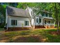 View of a home exterior with bay window and green shutters, nestled in a lush, wooded setting at 15 Pine Ridge, Pittsboro, NC 27312