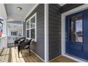 Inviting front porch with cozy chairs and a view of the neighborhood through the glass-paneled front door at 1526 Millrock Trl, Wendell, NC 27591