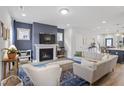 Comfortable living room with a fireplace, stylish furniture, and a blue accent wall with a modern aesthetic at 1526 Millrock Trl, Wendell, NC 27591