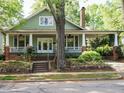 Inviting home with a covered porch, brick accents, and mature tree in a serene neighborhood setting at 1811 Park Dr, Raleigh, NC 27605