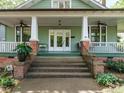 Welcoming front porch featuring classic columns, a fan, and a view of the address number '1811' at 1811 Park Dr, Raleigh, NC 27605