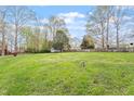 Spacious backyard featuring lush green grass, mature trees, and a wooden fence at 1813 Grady Dr, Durham, NC 27712