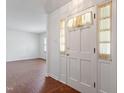 Bright entryway featuring light walls and trim, leading to living area with wood laminate flooring at 1813 Grady Dr, Durham, NC 27712