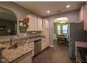 Eat-in kitchen featuring granite counters, stainless appliances, white cabinetry and an archway into the dining room at 198 Shadowbark Dr, Garner, NC 27529