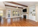 Spacious living room with hardwood floors, fireplace, built-in shelving, and wood beam ceiling at 2000 Monthaven Dr, Wake Forest, NC 27587