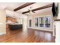Living room featuring hardwood floors, a stone fireplace, an adjacent kitchen and plenty of natural light at 2000 Monthaven Dr, Wake Forest, NC 27587