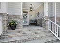 Inviting front porch with stone accents, a decorative wreath, and comfortable seating at 216 Bella Rose Dr, Chapel Hill, NC 27517