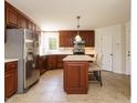 Well-equipped kitchen with stainless steel appliances, center island and tiled flooring at 2213 Ravens Creek Ct, Raleigh, NC 27603
