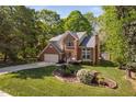 Two-story brick home with a well-maintained lawn, featuring a beautiful flowerbed and a two-car garage at 2221 Dungiven Ct, Garner, NC 27529