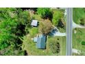 Aerial view of a home with a metal roof, adjacent to a road, featuring a detached garage and ample yard space at 2700 Chub Lake Rd, Roxboro, NC 27574
