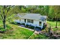 Quaint single-story home featuring a metal roof, freshly painted siding, and a lush green lawn with a landscaped walkway at 2700 Chub Lake Rd, Roxboro, NC 27574