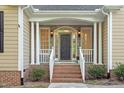 Charming front entrance with stone facade, brick steps, and covered porch at 2900 Old Trafford Way, Raleigh, NC 27606