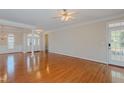 Spacious living room boasts gleaming hardwood floors, bright windows, and a ceiling fan at 308 Grove Hall Ln, Mebane, NC 27302