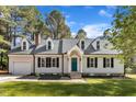 Charming home with a teal front door, black shutters, dormer windows and a well-manicured lawn at 3100 Greenville Loop Rd, Wake Forest, NC 27587