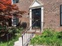 Inviting entrance of a brick townhouse, featuring well-manicured landscaping and a classic black door at 3125 Morningside Dr, Raleigh, NC 27607