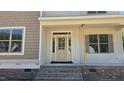 Inviting front porch featuring a classic front door and brick stairs, and shuttered windows at 317 Hampshire Court, Four Oaks, NC 27524