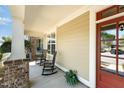Inviting front porch with rocking chairs, brick accents, and a red front door at 379 Tobacco Farm Way, Chapel Hill, NC 27516