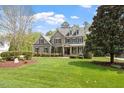 Charming two-story home featuring stone accents, gray siding, manicured lawn, and mature trees at 4213 Summer Brook Dr, Apex, NC 27539