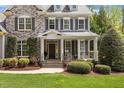 Inviting front porch with stone steps and a cozy seating area perfect for relaxing and enjoying the outdoors at 4213 Summer Brook Dr, Apex, NC 27539