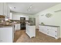 Well-equipped kitchen featuring white cabinets, stainless steel appliances, a kitchen island, and modern lighting fixtures at 4817 Quarryman Rd, Raleigh, NC 27610