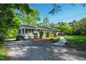 Ranch-style home with a well-kept lawn, lush greenery, and a paved driveway at 4902 Brookhaven Dr, Raleigh, NC 27612