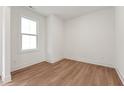Bright, empty bedroom with hardwood floors, white walls, and a large window offering natural light at 502 Gainer Dr # 2, Raleigh, NC 27610
