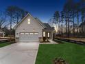 Exterior view of a modern farmhouse style home at twilight with a two-car garage and landscaped front yard at 502 Gainer Dr # 2, Raleigh, NC 27610