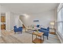 Bright living room with modern blue furniture, light wood floors, and neutral walls at 5110 Neuse Commons Ln # 109, Raleigh, NC 27616