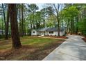 Wide view of a lovely white brick home with a well-manicured lawn and mature trees at 5312 Woodsdale Rd, Raleigh, NC 27606