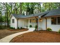 Charming single-story white brick home with copper gutters, blue door, and manicured landscaping at 5312 Woodsdale Rd, Raleigh, NC 27606