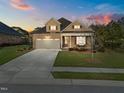 Lovely two-story home showcasing a two-car garage, covered porch, and a spacious driveway at 5733 Mizuno Dr, Fuquay Varina, NC 27526