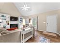 Comfortable living room featuring a fireplace, built-in shelves, large windows, and luxury vinyl plank flooring at 5911 Mountain Island Dr, Durham, NC 27713