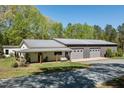 Beautiful exterior featuring white siding, metal roof, covered porch with swing, and an attached garage at 605 Faucette Mill Rd, Hillsborough, NC 27278