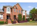 Elegant brick townhouse showcases lush landscaping and classic architectural details at 608 Derby Ct, Durham, NC 27707