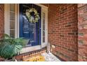 Close-up of a charming blue front door adorned with a wreath, welcoming guests at 608 Derby Ct, Durham, NC 27707