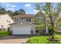 Inviting two-story home with a two-car garage, manicured lawn, and lovely landscaping on a sunny day at 617 Conover Rd, Durham, NC 27703