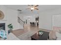 Open-concept living room with hardwood floors, fireplace, and stairs leading to the upper level at 633 Democracy St, Raleigh, NC 27603