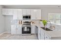Bright kitchen featuring white cabinets, stainless steel appliances, quartz countertops and subway tile backsplash at 6863 Paint Rock Ln, Raleigh, NC 27610