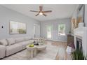 Inviting living room boasts neutral decor, ceiling fan, lots of natural light, and comfortable sofa at 6863 Paint Rock Ln, Raleigh, NC 27610