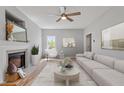 Cozy living room with fireplace, ceiling fan, neutral walls, wood floors, and comfortable seating arrangement at 6863 Paint Rock Ln, Raleigh, NC 27610