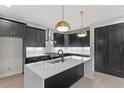 Modern kitchen featuring dark cabinets, white countertops, stainless steel appliances, and stylish pendant lighting at 730 Hopkins St, Durham, NC 27701