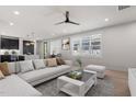 Bright living room featuring a modern ceiling fan, neutral color palette, and open floor plan to the kitchen at 730 Hopkins St, Durham, NC 27701