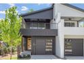 Modern two-story home with a black and white exterior, a covered balcony, and a two-car garage at 732 Hopkins St, Durham, NC 27701