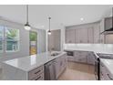 This is a modern kitchen with gray cabinets, stainless steel appliances, and a quartz countertop island at 732 Hopkins St, Durham, NC 27701