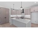 Beautiful kitchen featuring a large island with a white countertop and a modern range hood at 732 Hopkins St, Durham, NC 27701
