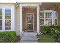Close-up of brick front door with decorative wreath and manicured bushes at 7613 Satinwing Ln, Raleigh, NC 27617